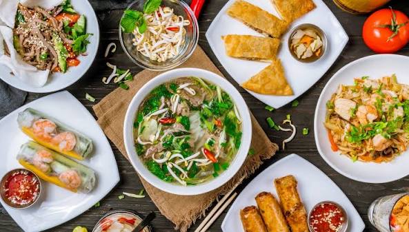 Vietnamese food with pho banh mi spring rolls and fresh herbs